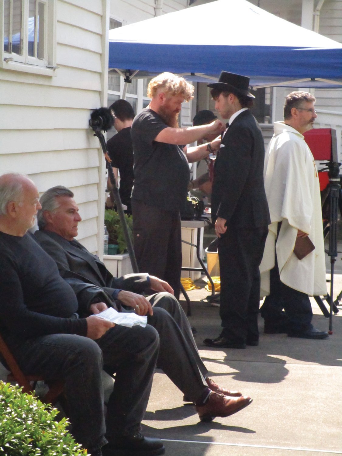 MIC ON: Adam Carbone, pictured in the top hat, is fitting with a microphone before the start of filming on Saturday at Sprague Mansion.